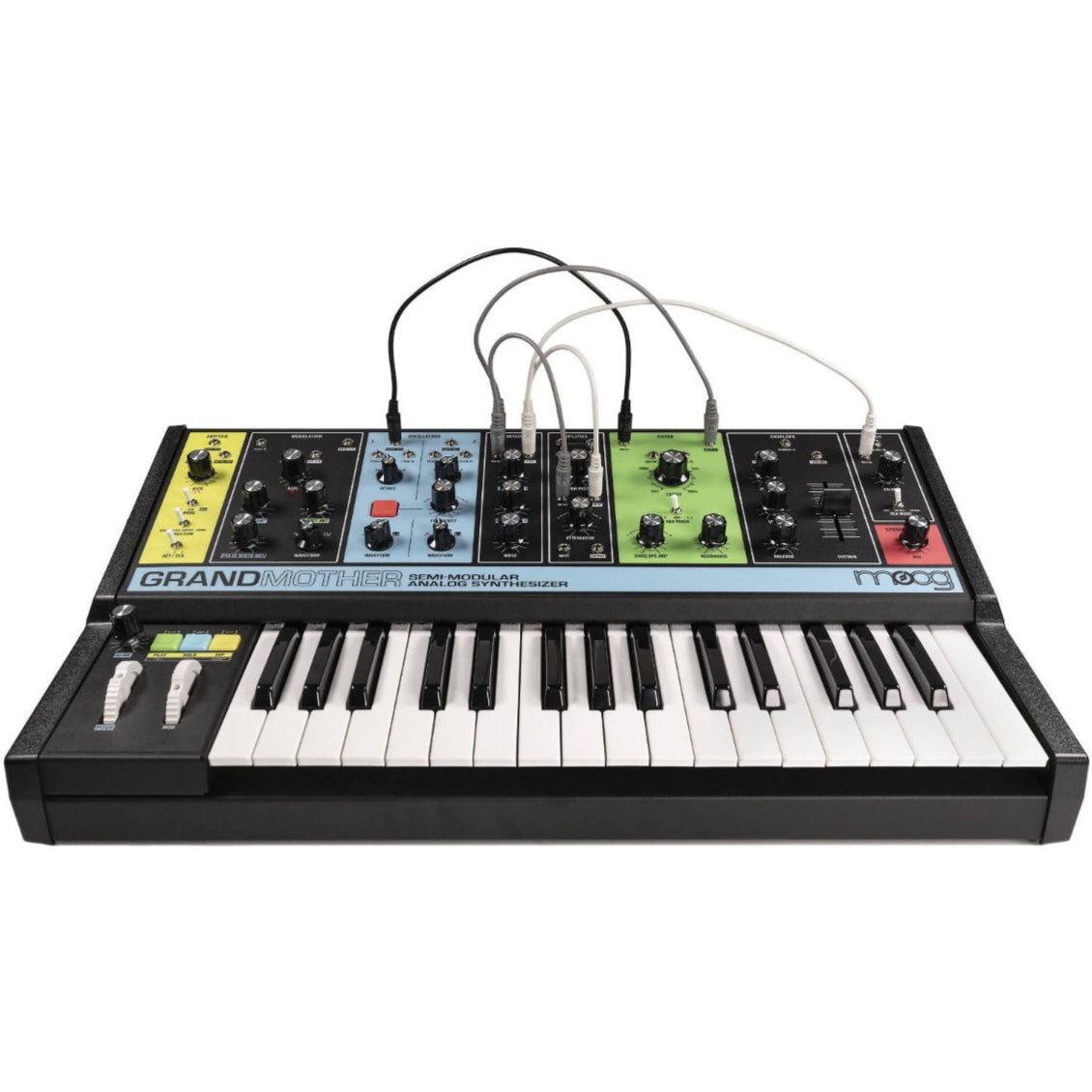 Moog Grandmother synthesizer with wooden sides and control knobs, showing its front panel and patch bay in a studio setting.