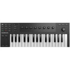 Native Instruments Komplete Kontrol M32 MIDI keyboard with 32 keys and control knobs, shown on a music studio desk.