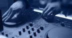 Native Instruments Traktor MX2 DJ controller with dual jog wheels, colorful performance pads, and various control knobs and faders.
