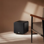 Q Acoustics Q SUB80 subwoofer with sleek black cabinet and front-firing speaker, designed for deep bass and home audio enhancement.