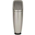 Samson C01U Pro USB microphone on a desk with a black stand, showing its cylindrical shape and professional audio equipment design.