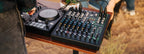 Mackie ProFX10 GO analog mixer with multiple input channels, knobs, and faders on a clean desktop setup.