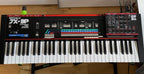 Dtronics DT-200 V3 synthesizer with Roland JX-3P setup, featuring control panel and vintage-style keyboard in a studio environment.