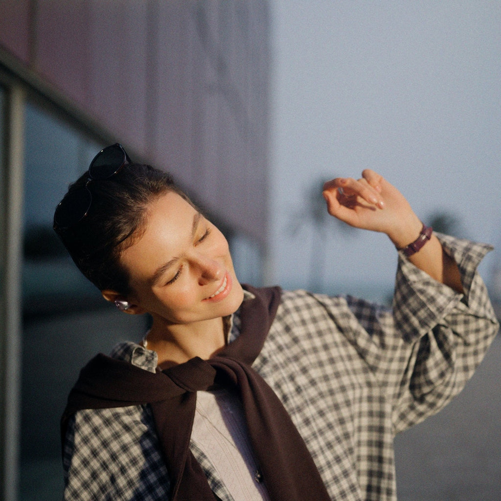 Woman dancing outdoors wearing Sennheiser Momentum True Wireless 5 earbuds