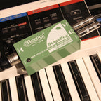 Radial Engineering StageBug SB-2 DI box connected to musical instruments, showing compact design and input/output jacks.