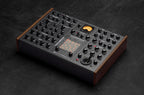 Erica Synths SYNTRX II desktop synthesizer with knobs, buttons, and display, showing its compact electronic music production interface.