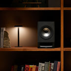 Black Technics SC-CX700 active bookshelf speakers on a stand with controls and connections visible.