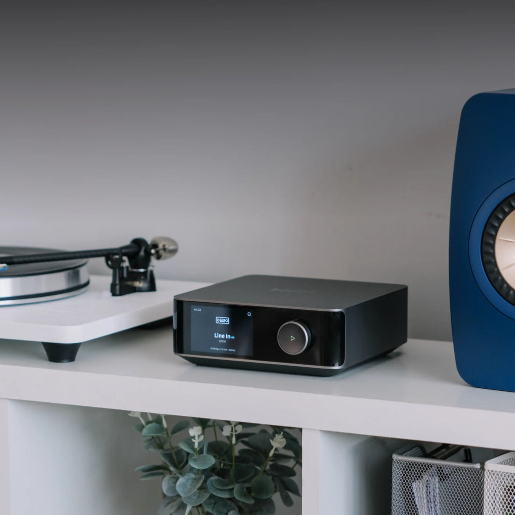 WiiM Amp Ultra stereo amplifier with sleek black design and control knobs, showcasing its compact and modern audio equipment.