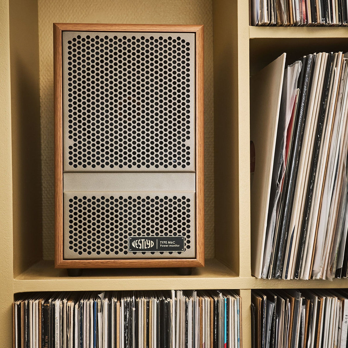 Vestlyd M6C Active in Oak on a shelf above a vinyl record collection
