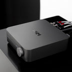 WiiM AMP music streamer displaying a sleek black device with LED indicators and control buttons on a modern home audio setup.